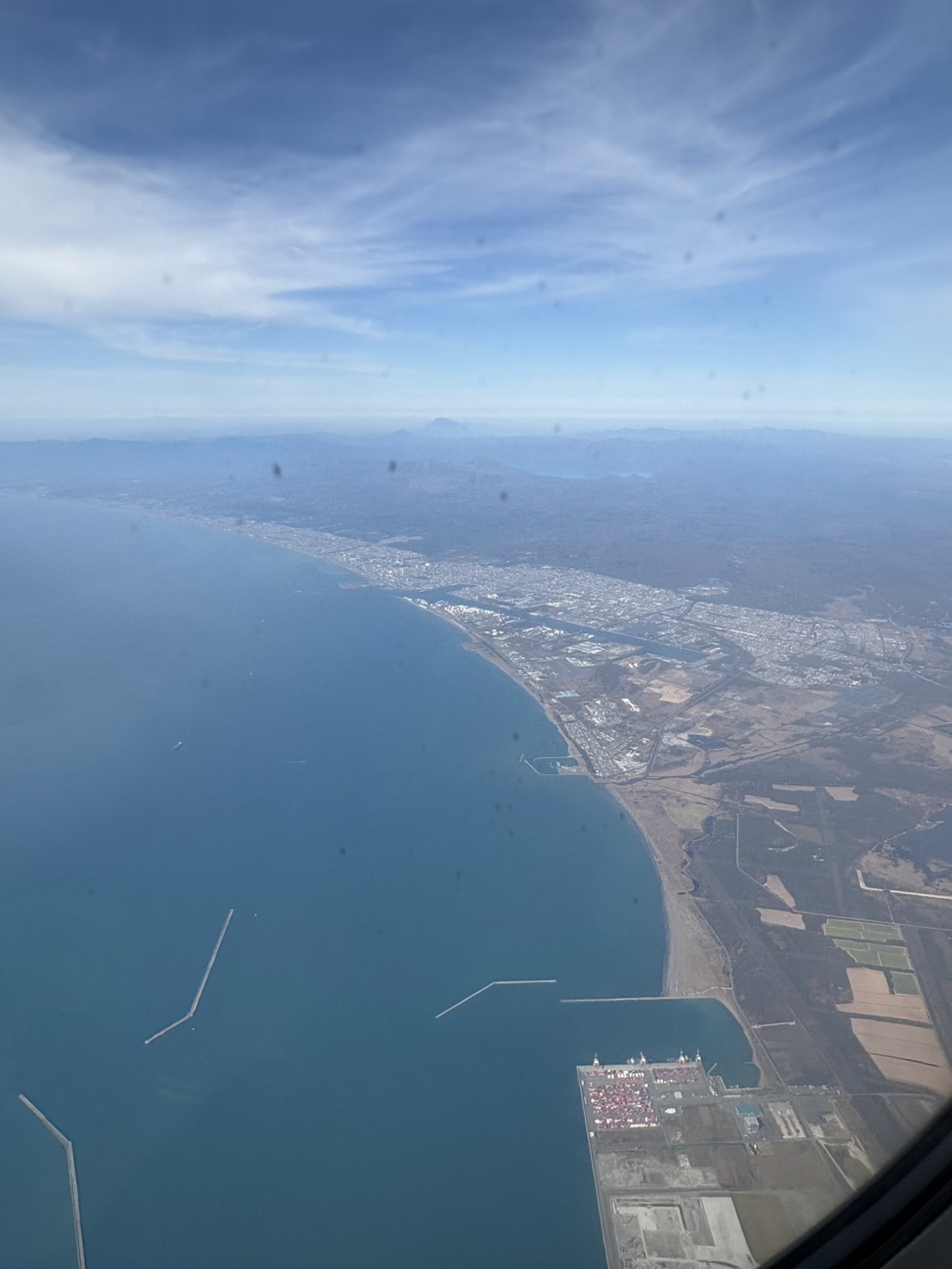飛行機の窓から眺めた北海道の青い空と海